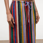 High-waisted, wide-leg Mateo pants featuring a colorful vertical stripe pattern, a drawstring waist, and a relaxed fit perfect for warm weather.