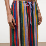 High-waisted, wide-leg Mateo pants featuring a colorful vertical stripe pattern, a drawstring waist, and a relaxed fit perfect for warm weather.