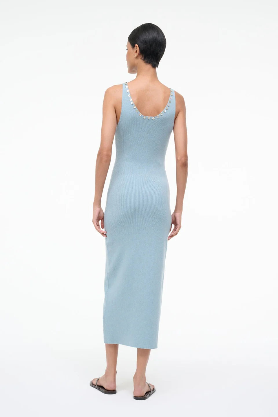 Back view of the Neva Dress, a sophisticated, light blue ribbed midi dress with circular button details along the back neckline for a timeless style.