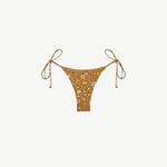 Praia Bottom: A gold beaded bikini bottom featuring a delicate white floral print, thin adjustable side ties embellished with beads, and a high-cut silhouette, made from recycled nylon swimwear material and showcased on a plain white background.
