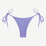 The Praia Bottom, an adjustable tie bikini bottom in a soft lavender shade and crafted from regenerated nylon for enhanced comfort, is showcased against a plain white background—a perfect option for anyone looking for eco-friendly swimwear with a customizable fit.