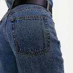 KABE SHOP INC Everyday Jeans in medium wash denim with a back pocket featuring SH embroidery and a black leather belt.