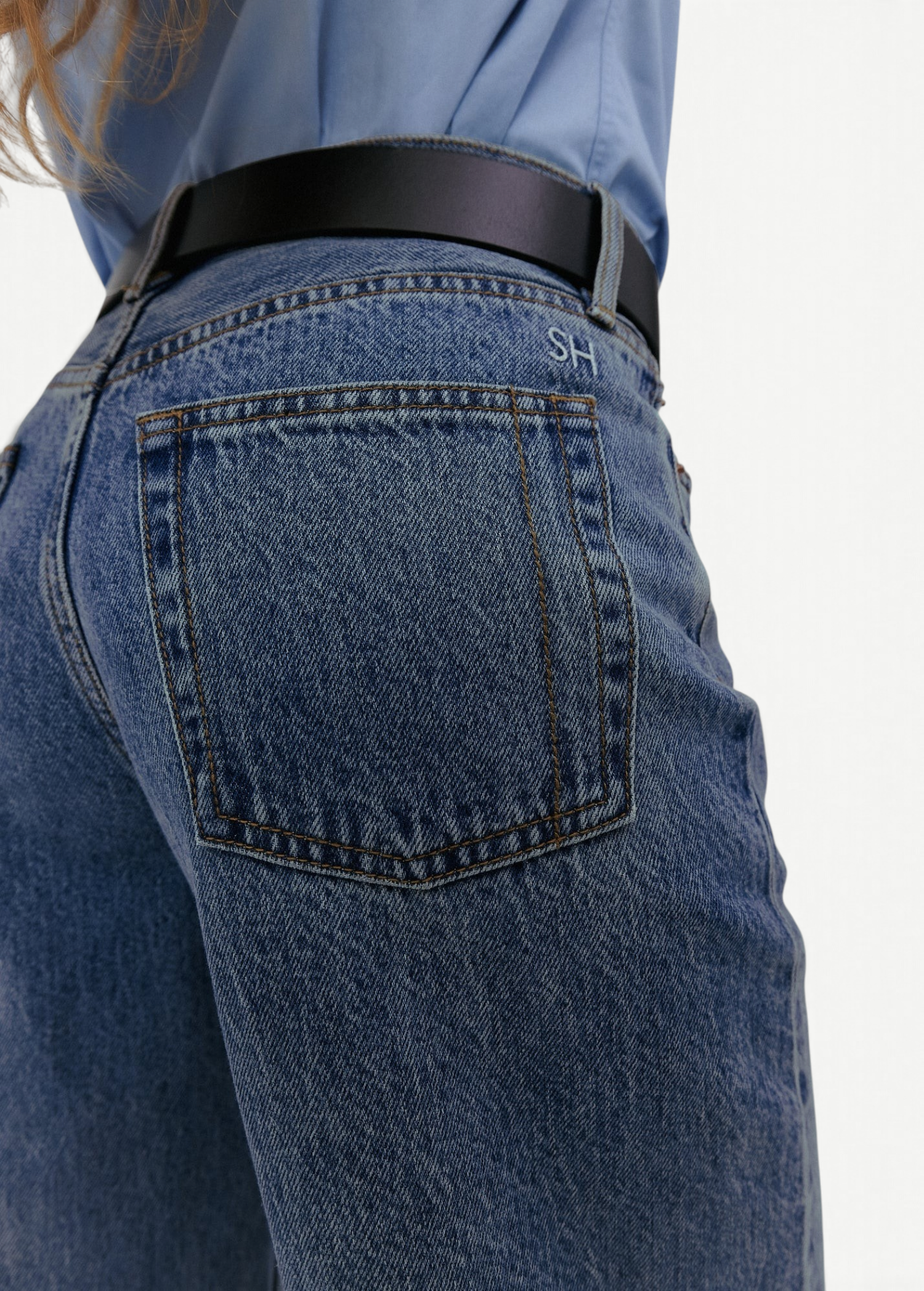KABE SHOP INC Everyday Jeans in medium wash denim with a back pocket featuring SH embroidery and a black leather belt.