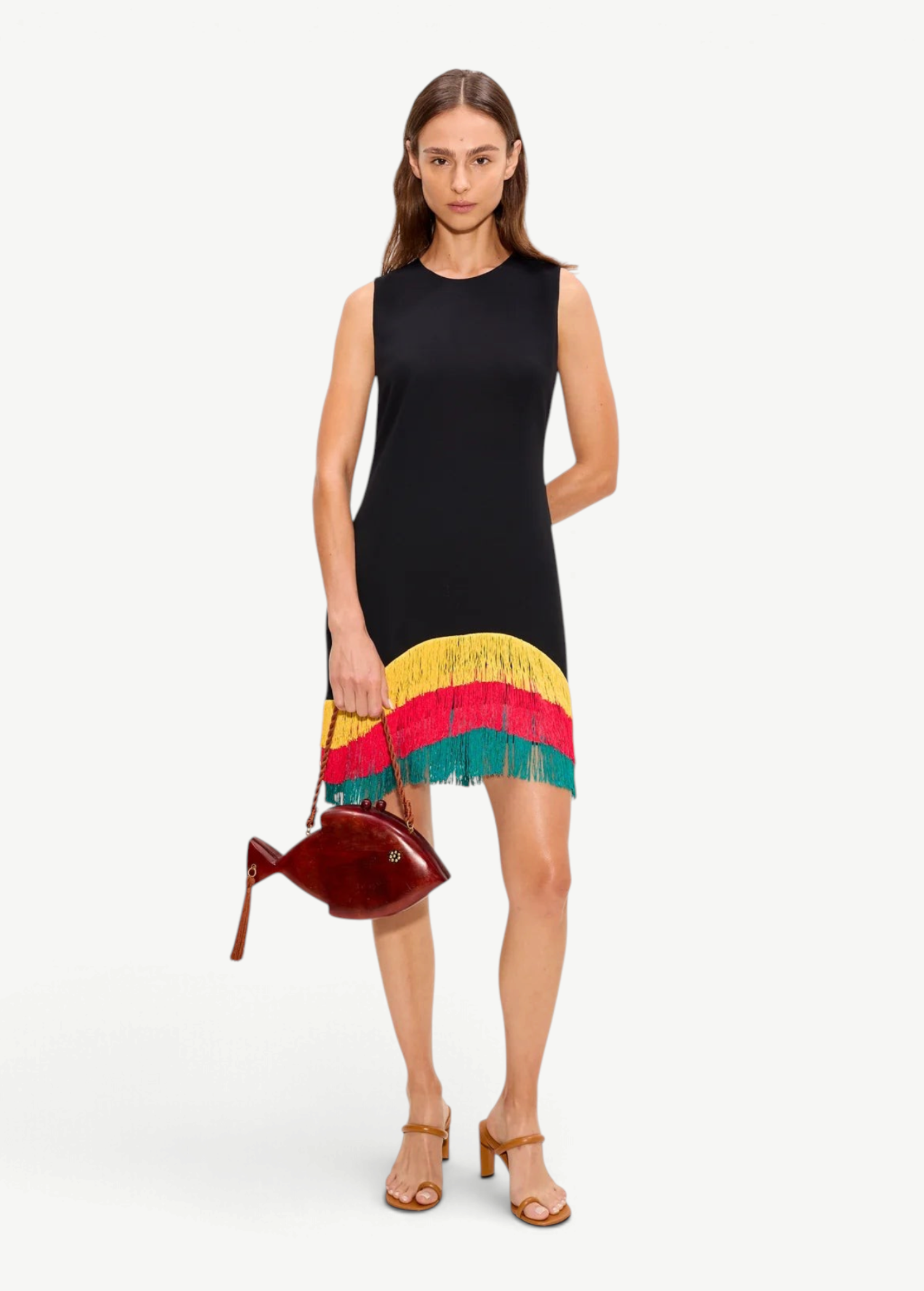 Model wearing KABE SHOP INC Bowie mini dress with black bodice and yellow, red, and green fringe hem