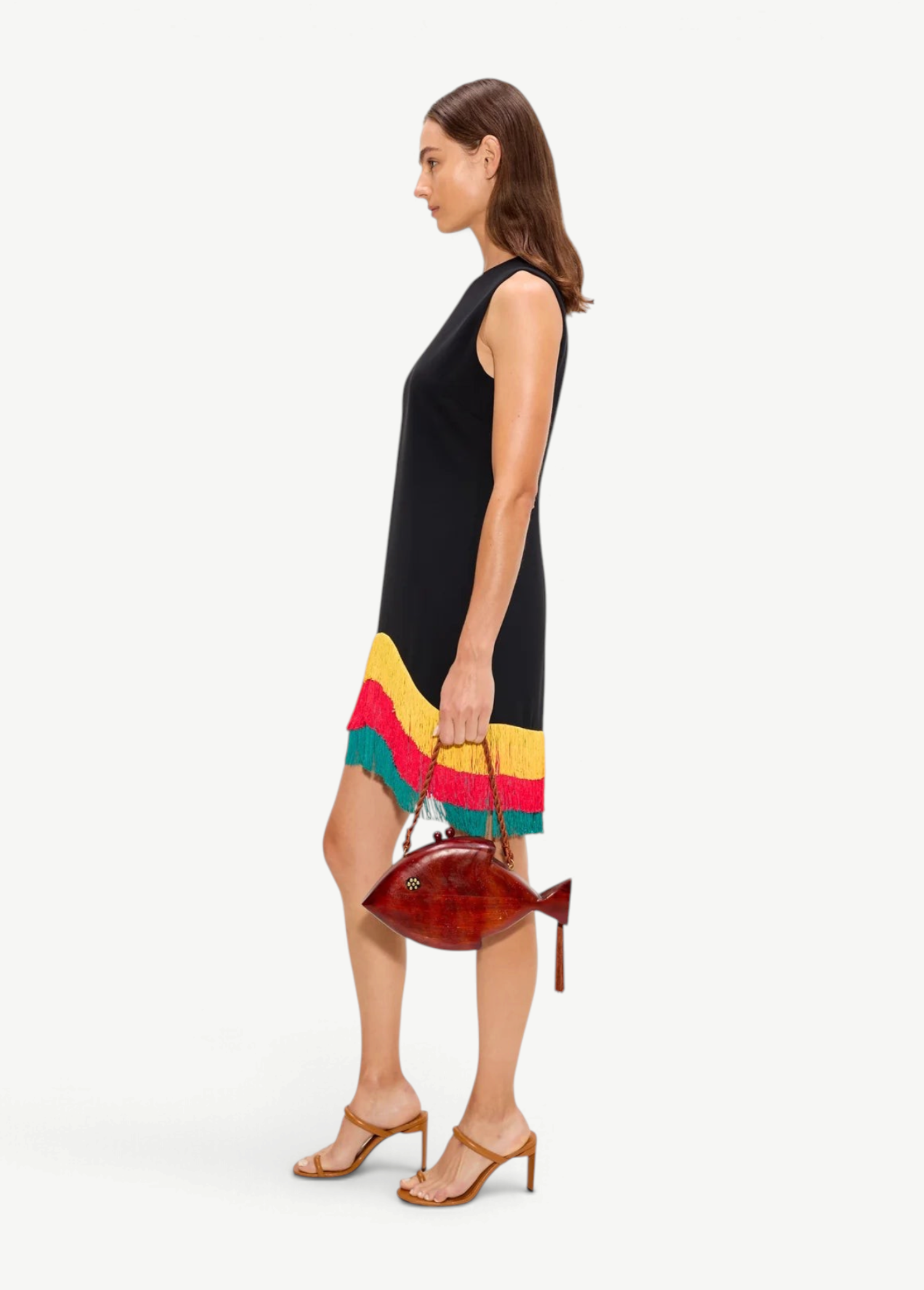 Model wearing KABE SHOP INC Bowie fringe mini dress in black with yellow and green hem detail and brown fish bag