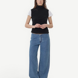 Model wearing KABE SHOP INC Sport Jean in relaxed blue denim with a black zip-up top against a plain background