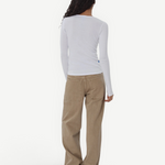 Model wearing KABE SHOP INC Sport Jean in tan denim with a relaxed fit, paired with a white long-sleeve top.
