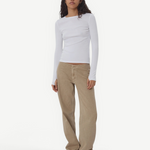 Model wearing KABE SHOP INC Sport Jean in tan denim with a relaxed fit and white long-sleeve top