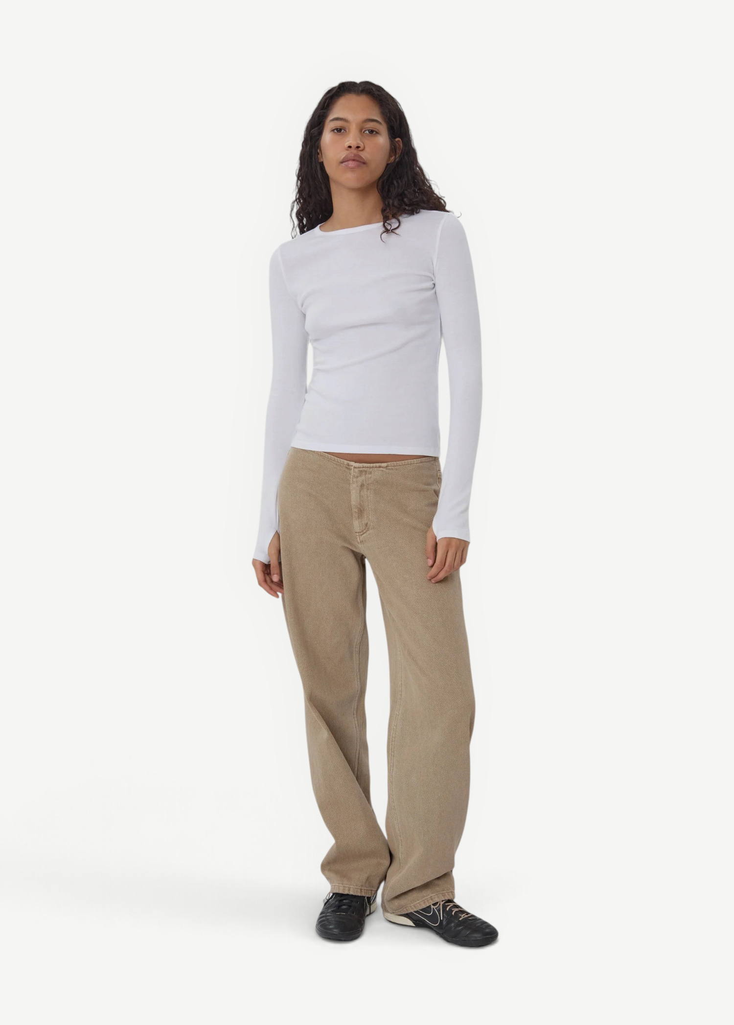 Model wearing KABE SHOP INC Sport Jean in tan denim with a relaxed fit and white long-sleeve top
