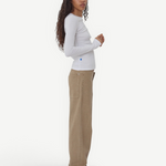 Model wearing KABE SHOP INC Sport Jean in tan denim with a relaxed fit, paired with a white long-sleeve top.