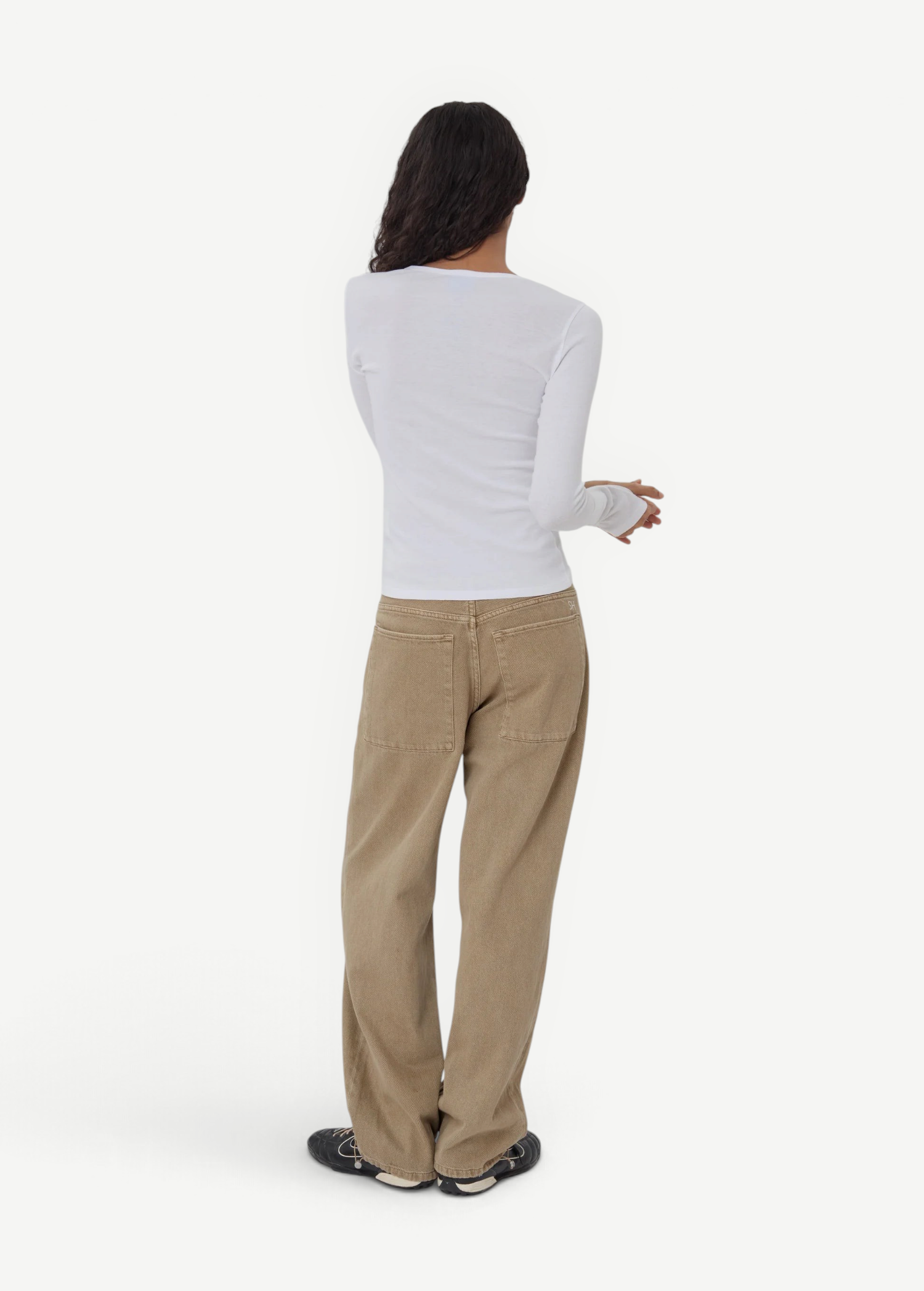 Model wearing KABE SHOP INC Sport Jean in tan denim with a relaxed fit and patch pockets, paired with a white top.