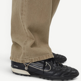 KABE SHOP INC Sport Jean in tan denim with a relaxed fit and adjustable drawstring hem, worn with black sneakers.