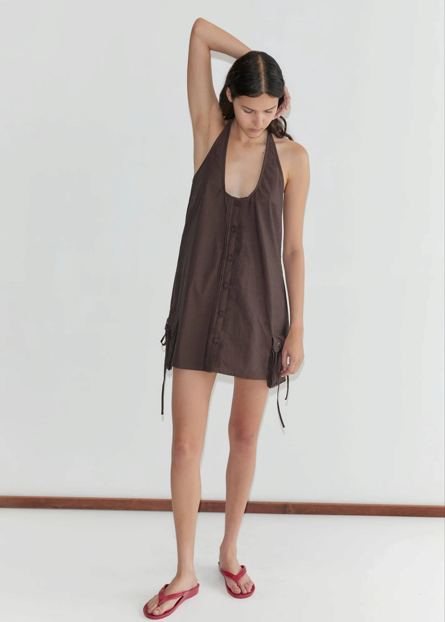 Model wearing KABE SHOP INC brown Deiji Studios pocket halter dress with pintuck details and adjustable neckline.