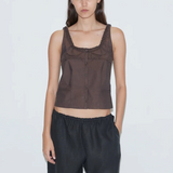 Model wearing KABE SHOP INC Deiji Studios brown cotton poplin tank top with frill detailing and button-through front.
