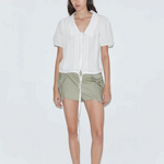 KABE SHOP INC Deiji Studios white cotton poplin top with collared V-neck, pintuck details, and drawcord hem on model