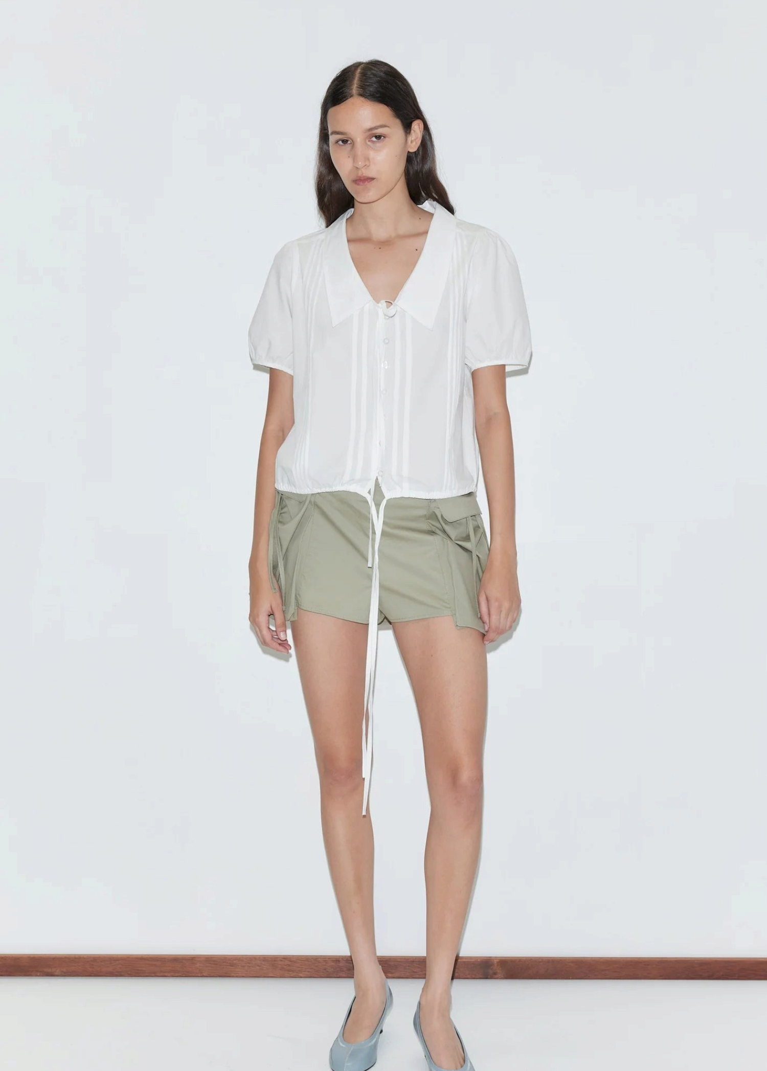 KABE SHOP INC Deiji Studios white cotton poplin top with collared V-neck, pintuck details, and drawcord hem on model