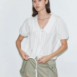 KABE SHOP INC Deiji Studios white cotton poplin top with collared V-neck, pintuck details, and adjustable drawcord hem.