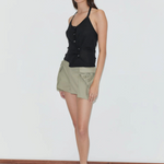 A person wears a fitted knit Cross Top with a front button placket, olive green cargo shorts with side pockets, and black flip-flops.