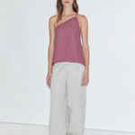 Model wearing a mauve linen one-shoulder Half Halter top by KABE SHOP INC with gathered neckline and back tie