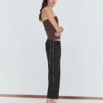A person wearing a brown strapless top, black Deiji Studios Capri Pant, and light blue kitten heels in a relaxed style.