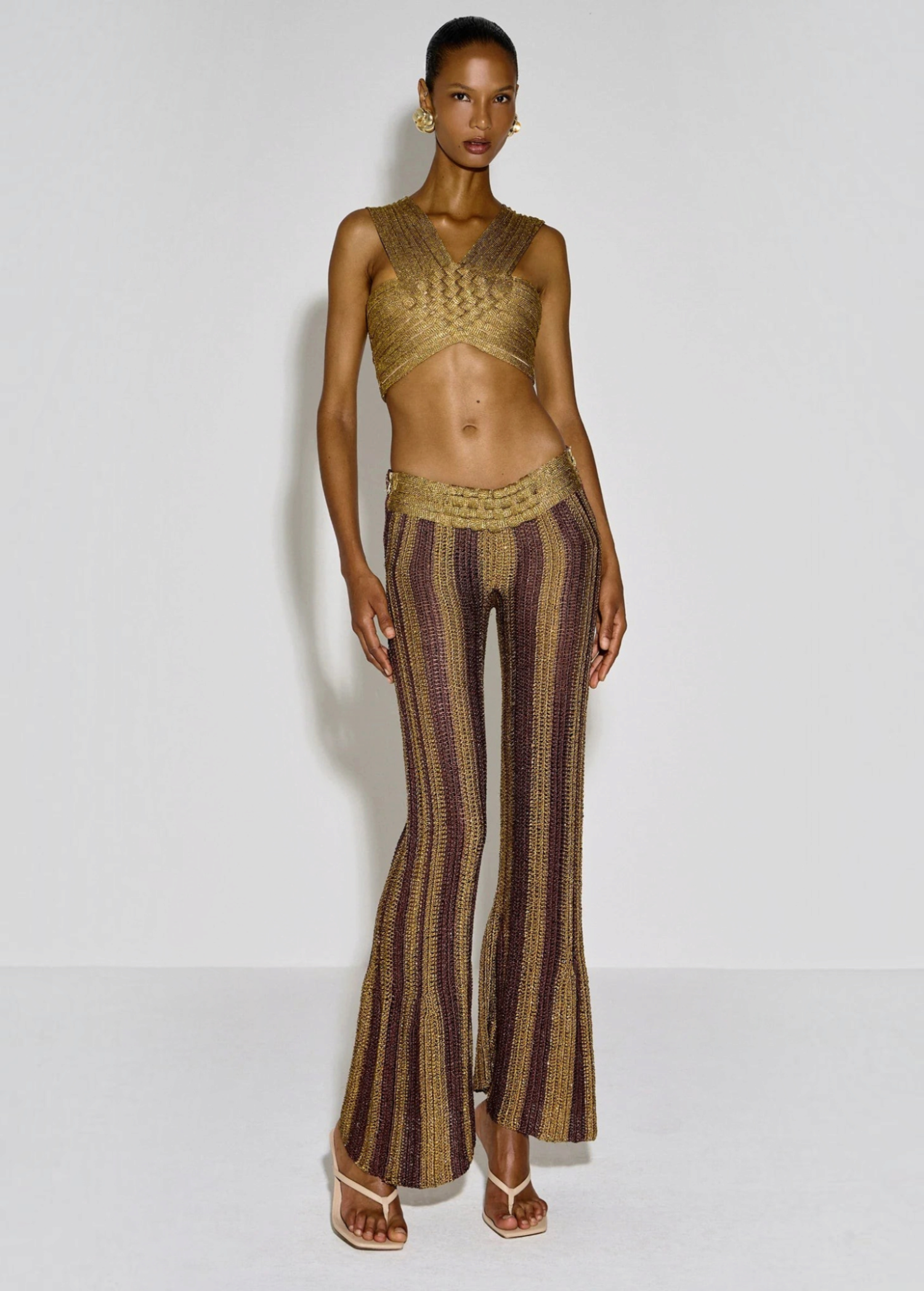 KABE SHOP INC Cher Set featuring a metallic gold and brown striped crochet crop top and matching flared trousers.