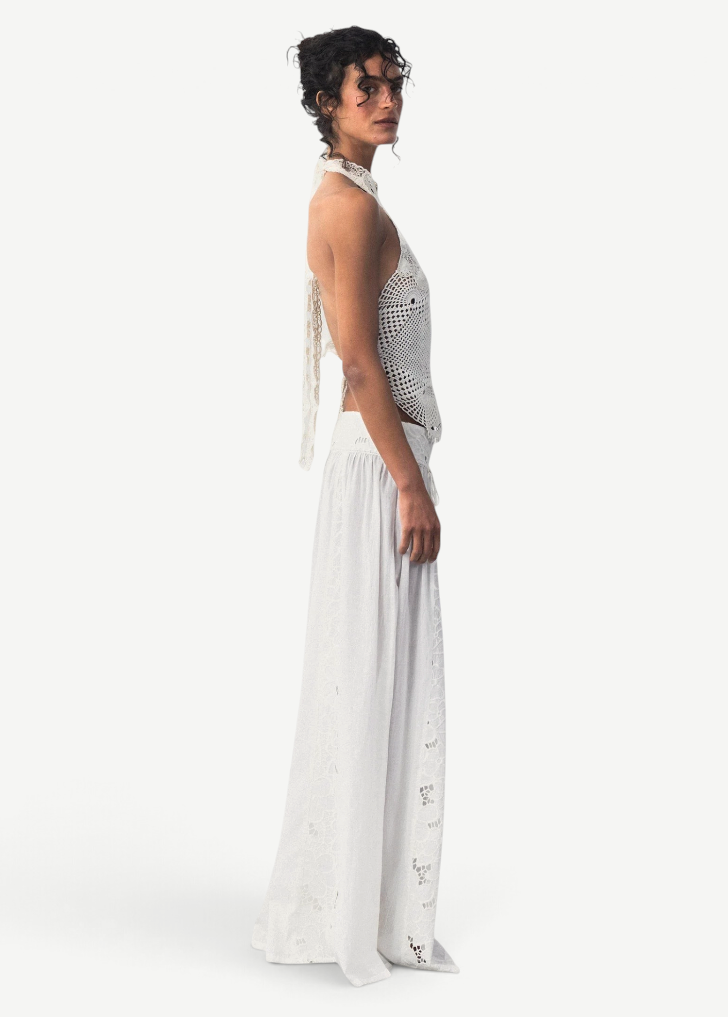 KABE SHOP INC Menorca trousers in white cotton with intricate lace patterns worn by a model in a side profile view