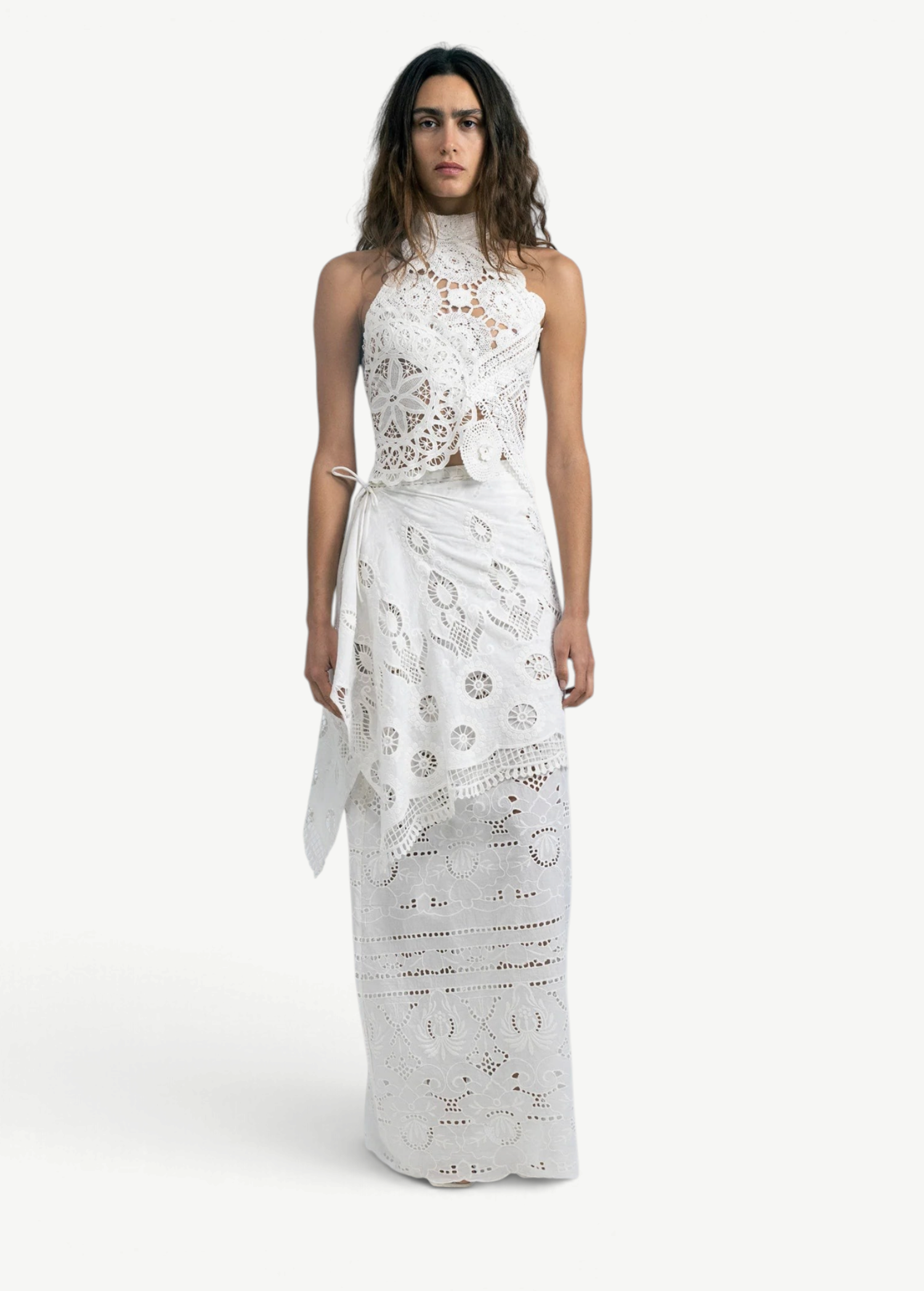 Model wearing KABE SHOP INC Katinka white cotton skirt with intricate crochet and lace patchwork details.
