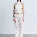 Model wearing KABE SHOP INC white lace trousers with a handkerchief-inspired waistband and matching lace halter top.