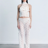 Model wearing KABE SHOP INC white lace trousers with a handkerchief-inspired waistband and matching lace halter top.
