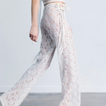 KABE SHOP INC white lace trousers with a strappy handkerchief waistband and a fitted silhouette on a model.