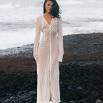 KABE SHOP INC Mirror Dress in sheer white fabric with silver embellishments on a model standing on a rocky beach