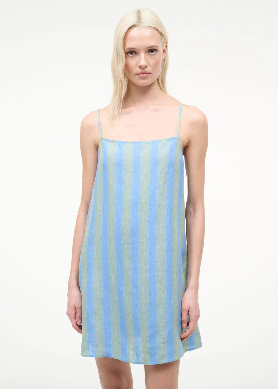 The Laura Mini Dress is a sleeveless mini dress for warm-weather dressing featuring thin shoulder straps and vertical blue and green stripes.