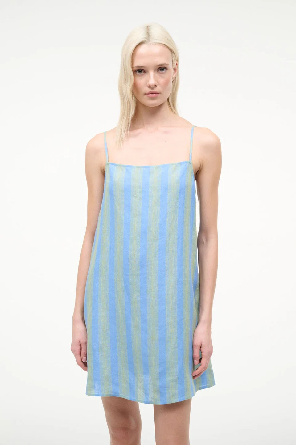 The Laura Mini Dress is a sleeveless mini dress for warm-weather dressing featuring thin shoulder straps and vertical blue and green stripes.