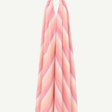 The Halter Dress V-Neck is a sleeveless maxi dress with a halter neckline, crafted from handwoven cotton and adorned with pink, peach, and white diagonal stripes that capture the vibrant essence of Marrakech—displayed on a white background.