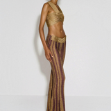 Model wearing KABE SHOP INC Cher Set featuring a metallic gold crop top and striped burgundy and gold flared trousers.