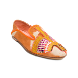 The Anzu Moccasin is an orange and tan slip-on featuring pink, yellow, and gold hand-embroidered patterns on the upper. With a flat sole and rounded toe, this sustainable shoe is inspired by the classic moccasin and is displayed on a white background.