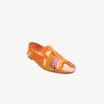 The Anzu Moccasin is an orange and tan slip-on featuring pink, yellow, and gold hand-embroidered patterns on the upper. With a flat sole and rounded toe, this sustainable shoe is inspired by the classic moccasin and is displayed on a white background.