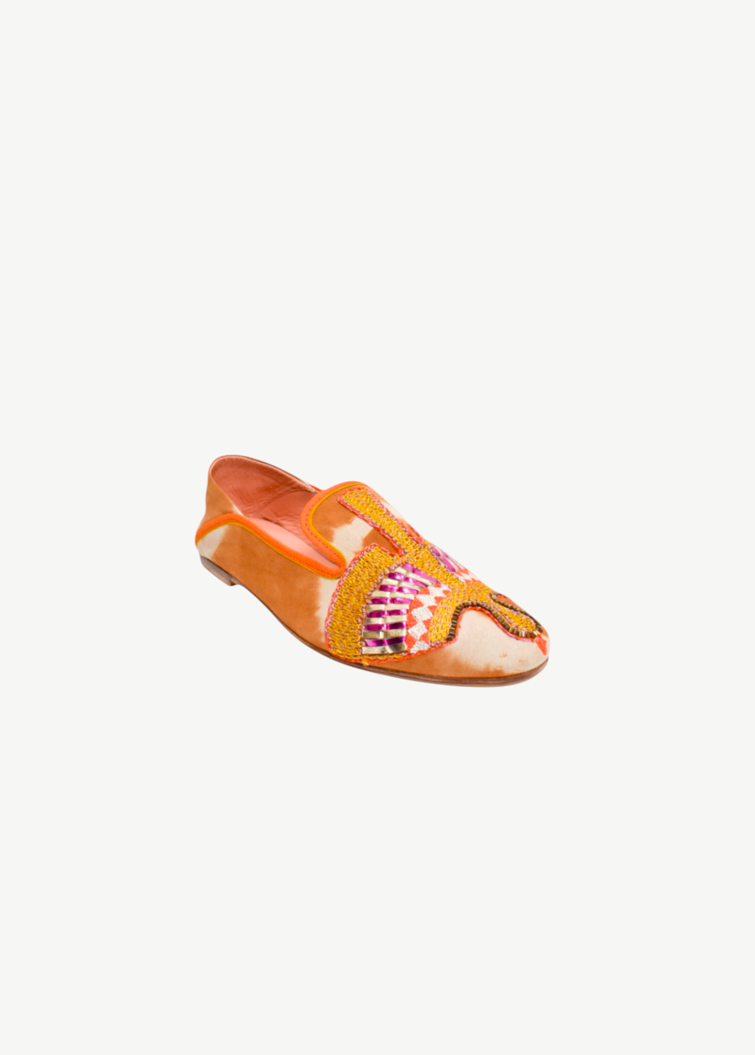 The Anzu Moccasin is an orange and tan slip-on featuring pink, yellow, and gold hand-embroidered patterns on the upper. With a flat sole and rounded toe, this sustainable shoe is inspired by the classic moccasin and is displayed on a white background.