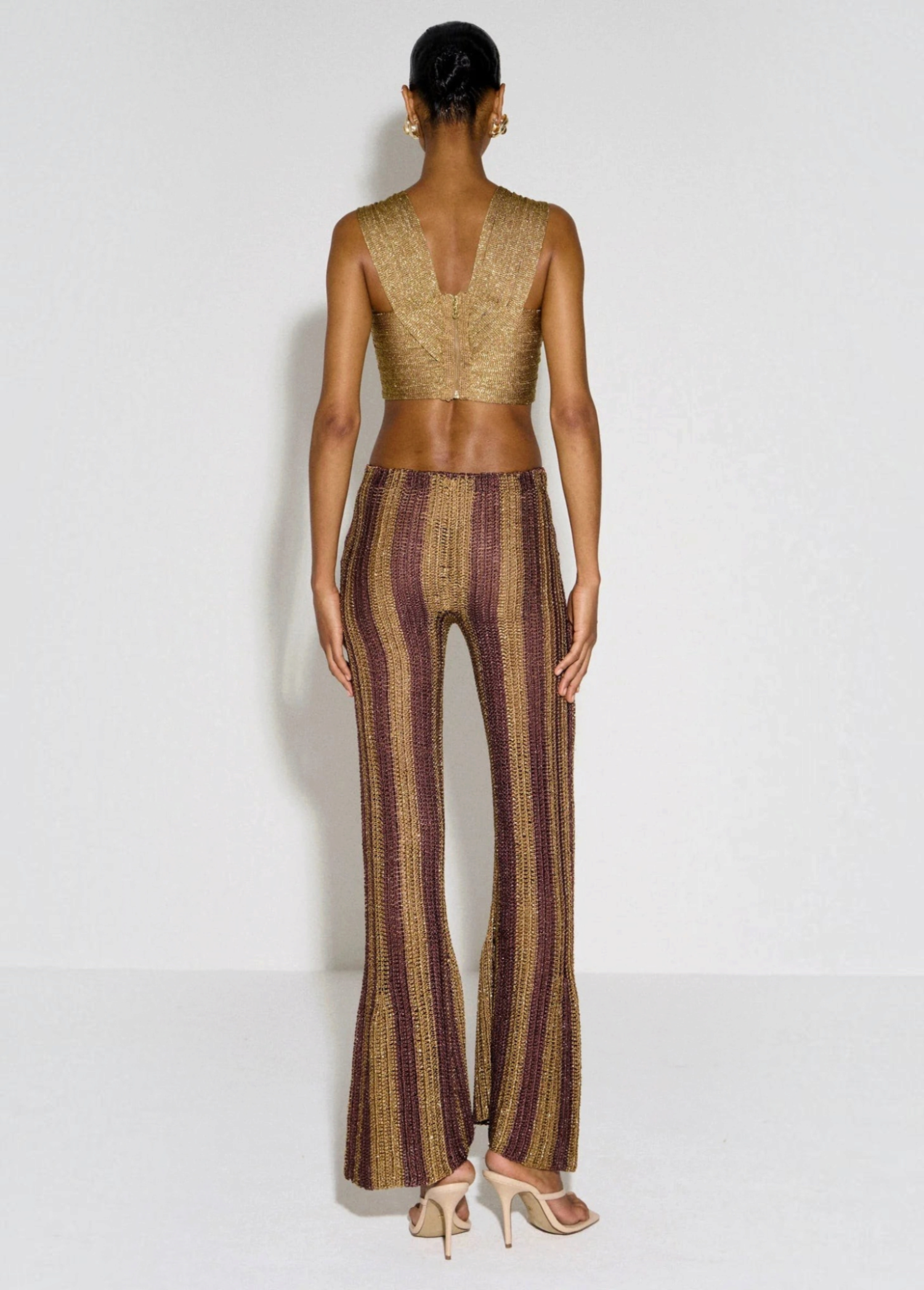 Back view of KABE SHOP INC Cher Set featuring a gold metallic crop top and striped wide-leg trousers on a model.