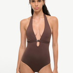 A woman wearing a deep brown La Jolla Swimwear La Jolla One Piece, a halter-style swimsuit featuring a silver ring detail at the center cutout.