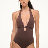 A woman wearing a deep brown La Jolla Swimwear La Jolla One Piece, a halter-style swimsuit featuring a silver ring detail at the center cutout.