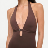 A brown La Jolla Swimwear one-piece swimsuit with a deep halter neckline and a silver crescent-shaped hardware accent at the center.