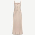 The Greta Dress is a pale pink sleeveless maxi dress with a square neckline and vertical rows of small circular embellishments, perfect for elegant evening dressing.