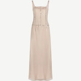 The Greta Dress is a pale pink sleeveless maxi dress with a square neckline and vertical rows of small circular embellishments, perfect for elegant evening dressing.