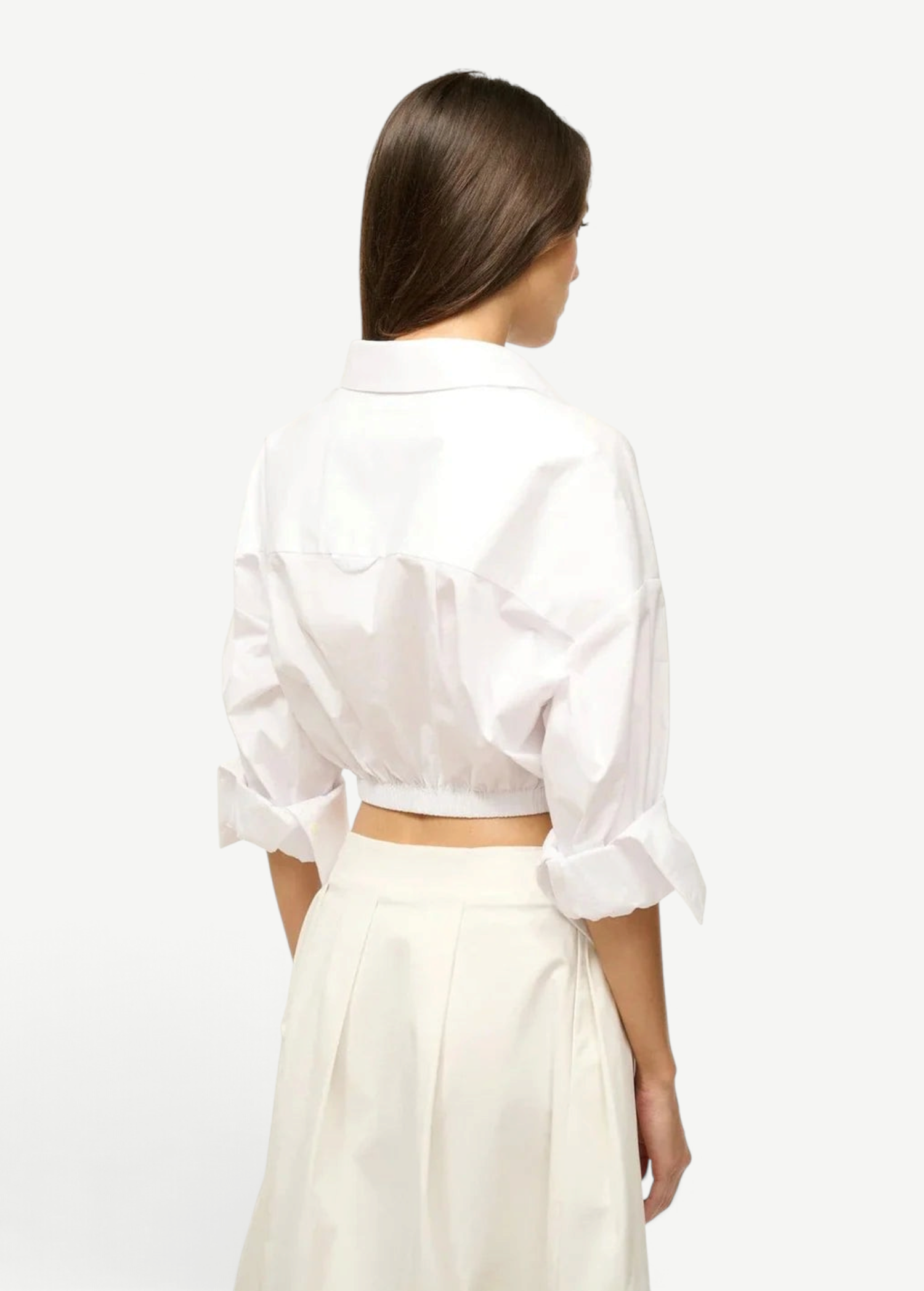 Back view of a person wearing the white Lisa Top, featuring a collared neckline, three-quarter length cuffed sleeves, and a wide elastic hem, styled for everyday dressing.