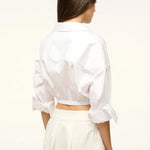 Back view of a person wearing the white Lisa Top, featuring a collared neckline, three-quarter length cuffed sleeves, and a wide elastic hem, styled for everyday dressing.