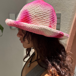 KABE SHOP INC handmade crochet bucket hat in vibrant pink and white tie-dye worn by a woman in profile