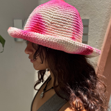 KABE SHOP INC handmade crochet bucket hat in vibrant pink and white tie-dye worn by a woman in profile
