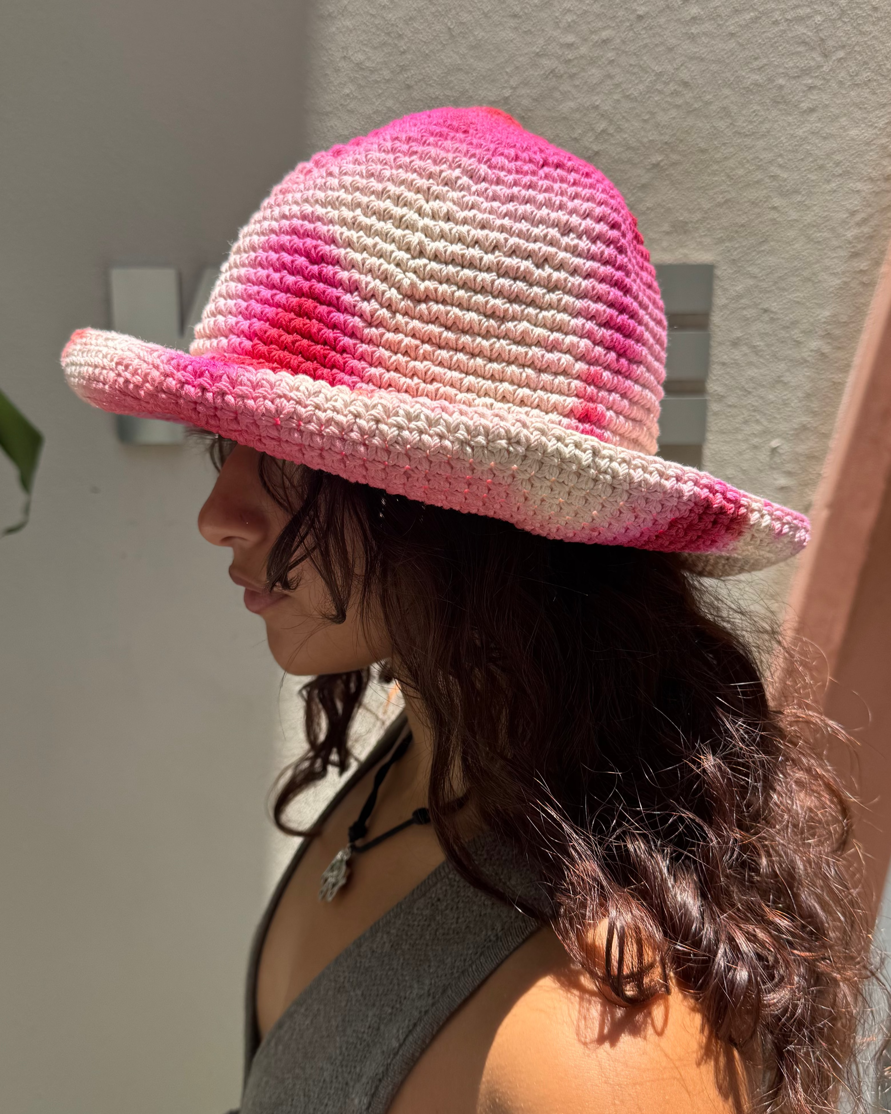 KABE SHOP INC handmade crochet bucket hat in vibrant pink and white tie-dye worn by a woman in profile