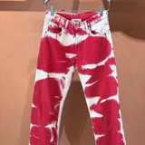 Red and white Tie Dye Jeans in a vintage style on a clothes hanger.